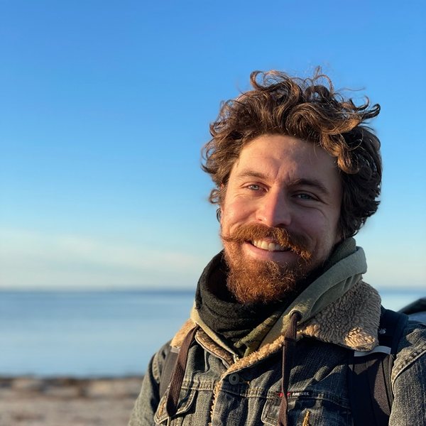 Portrait of Dennis, smiling, on a beach in winter sunlight